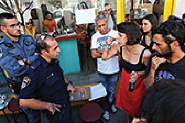 אורטל בן דיין מתווכחת עם שוטר שבא לסגור את הקפה. צילום: יותם רונן