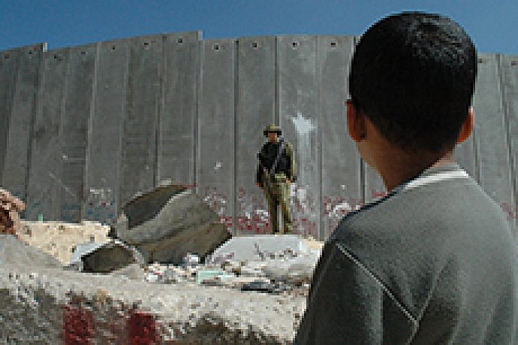 ילד פלסטיני וחייל ישראלי ליד גדר ההפרדה. צילום: אימג'בנק/ Getty Images