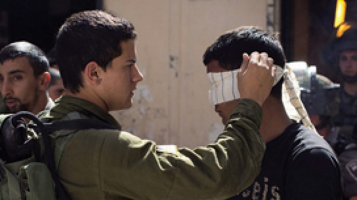 חייל צה"ל עוצר פלסטיני. צילום: אורן זיו