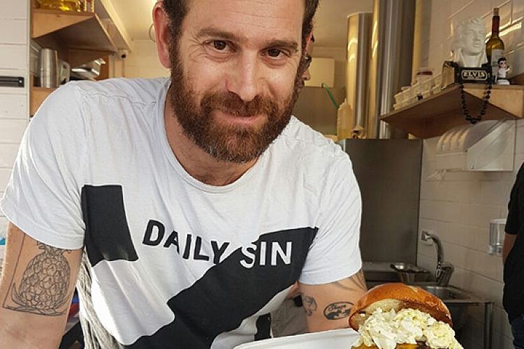 עומר מילר עם המבורגר מפלצתי . סוסו אנד סאנס. צילום: נועה רוזין