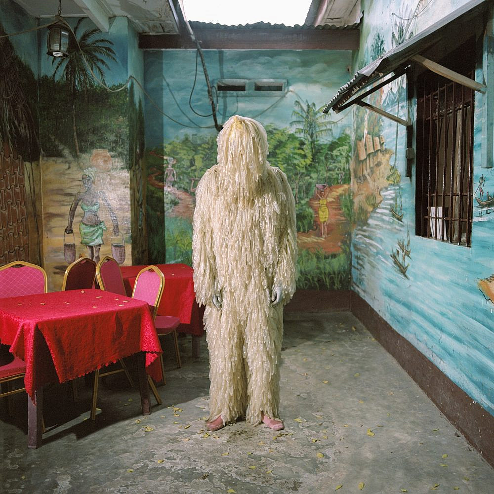 Congolese artist Tickson Mbuyi posing in his condom costume in “Bon Marché” district, a popular nightlife neighborhood in Kinshasa.