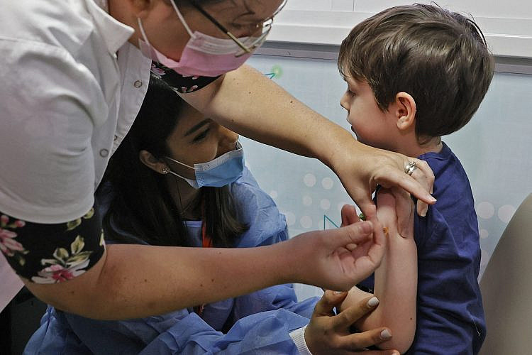איתמר (5) מתחסן במרכז החיסונים של מאוחדת פה בעיר. צילום: Photo by JACK GUEZ / AFP