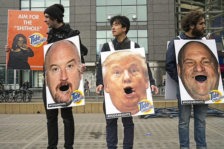 פעילים עם שלטים נגד סי.קיי, טראמפ וויינשטיין במהלך מצעד הנשים ב-2018 בניו יורק. צילום: Andrew Holbrooke/Getty Images