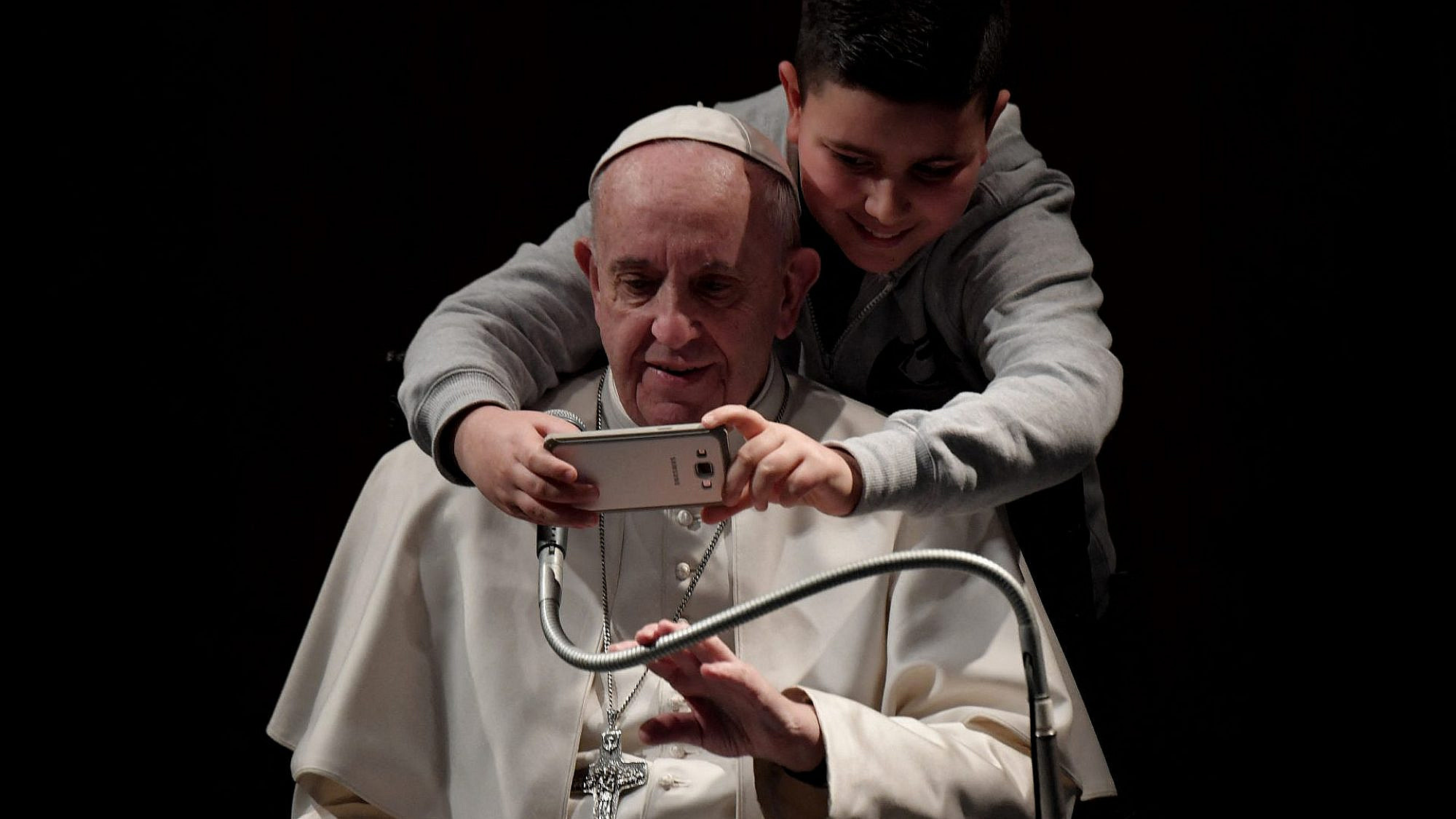 אל תגידו שלא הזהרנו. ילד עם סמארטפון ואפיפיור (צילום: טיציאנה פאבי/AFP/גטי אימג'ס)