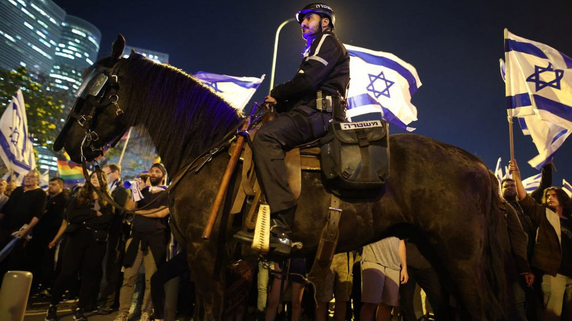 שוטר וסוס משקיפים על ההפגנה בקפלן. 26.3. צילום: גיל כהן-מגן/AFP via Getty Images