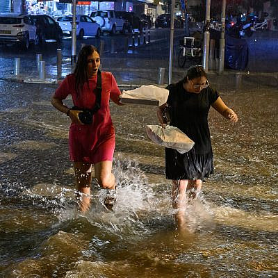 והנה איך לא להתחמם בלילה תל אביבי חורפי. נשים חוצות נחל תל אביבי עונתי (צילום: לאון ניל/גטי אימג'ס)