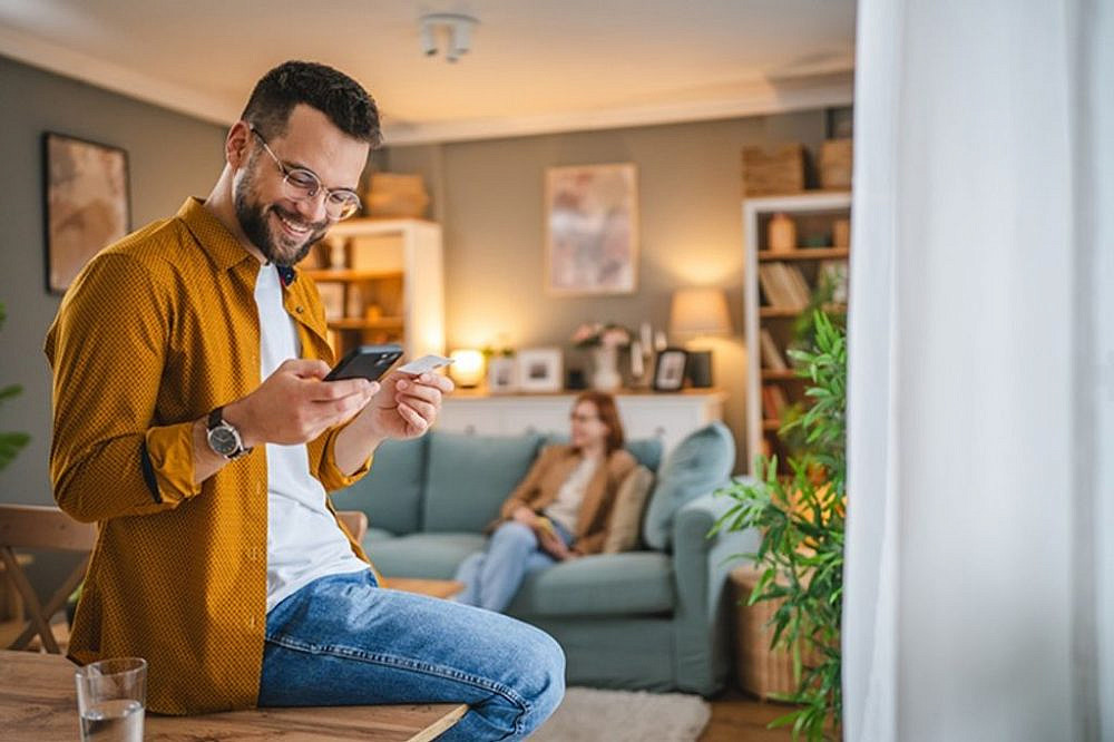 גבר קונה אונליין באמצעות הטלפון. צילום: Shutterstock