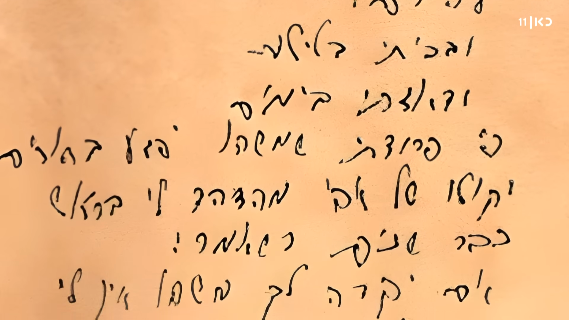 מילות השיר בכתב ידו של ארז שטרק ז"ל (צילום מסך: כאן 11)